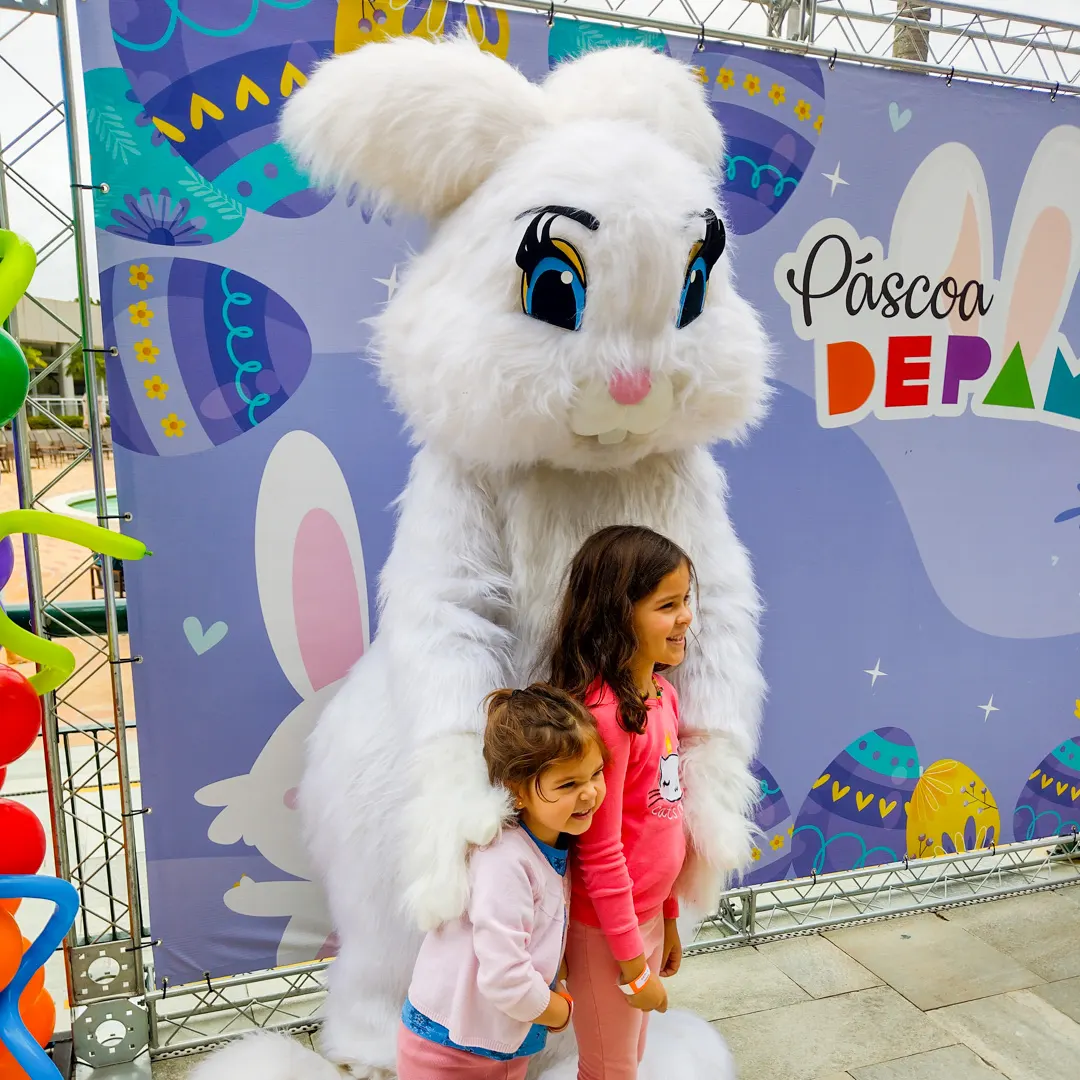 Ator vestindo fantasia de luxo de Coelho da Páscoa acenando em evento infantil.