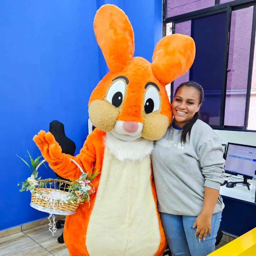 Crianças abraçando com alegria o Coelho Laranja Personagem Vivo durante evento festivo em São Paulo
