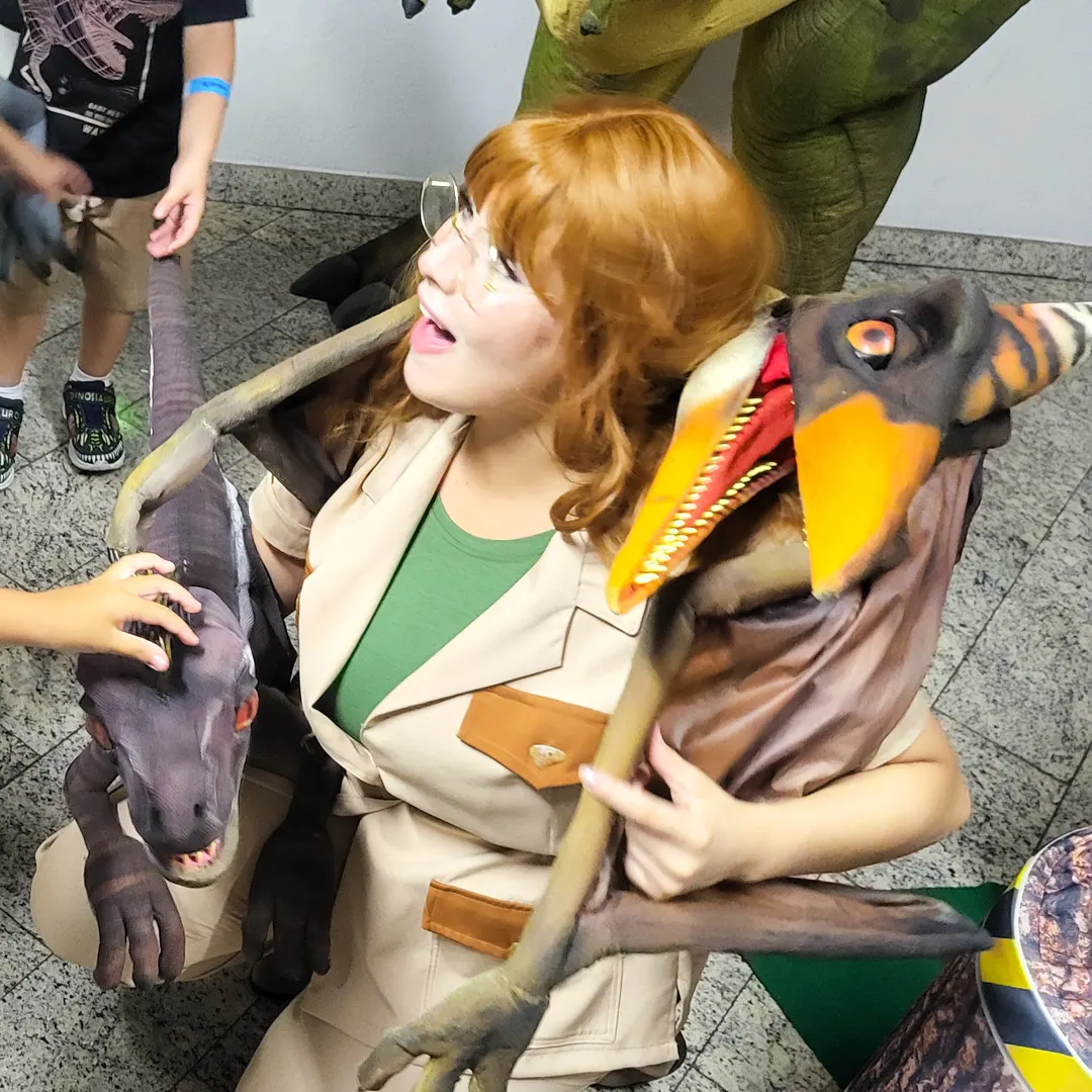 Crianças encantadas abraçando o Pterodáctilo Baby Personagem Vivo no aniversário