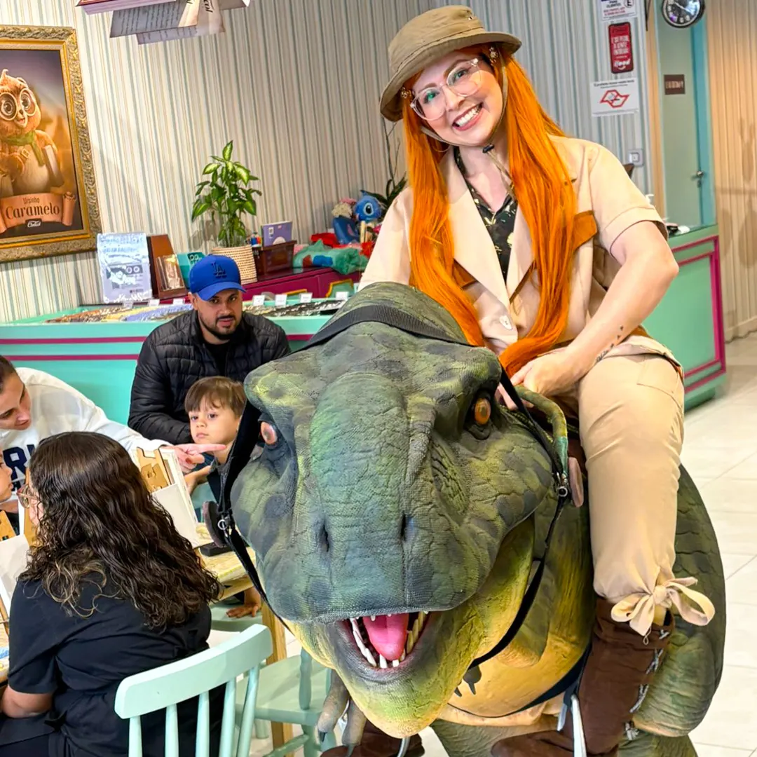 Crianças pequenas acariciando o dócil Baby T-Rex Personagem Vivo na festa de aniversário Crianças pequenas acariciando o dócil Baby T-Rex Personagem Vivo na festa de aniversário