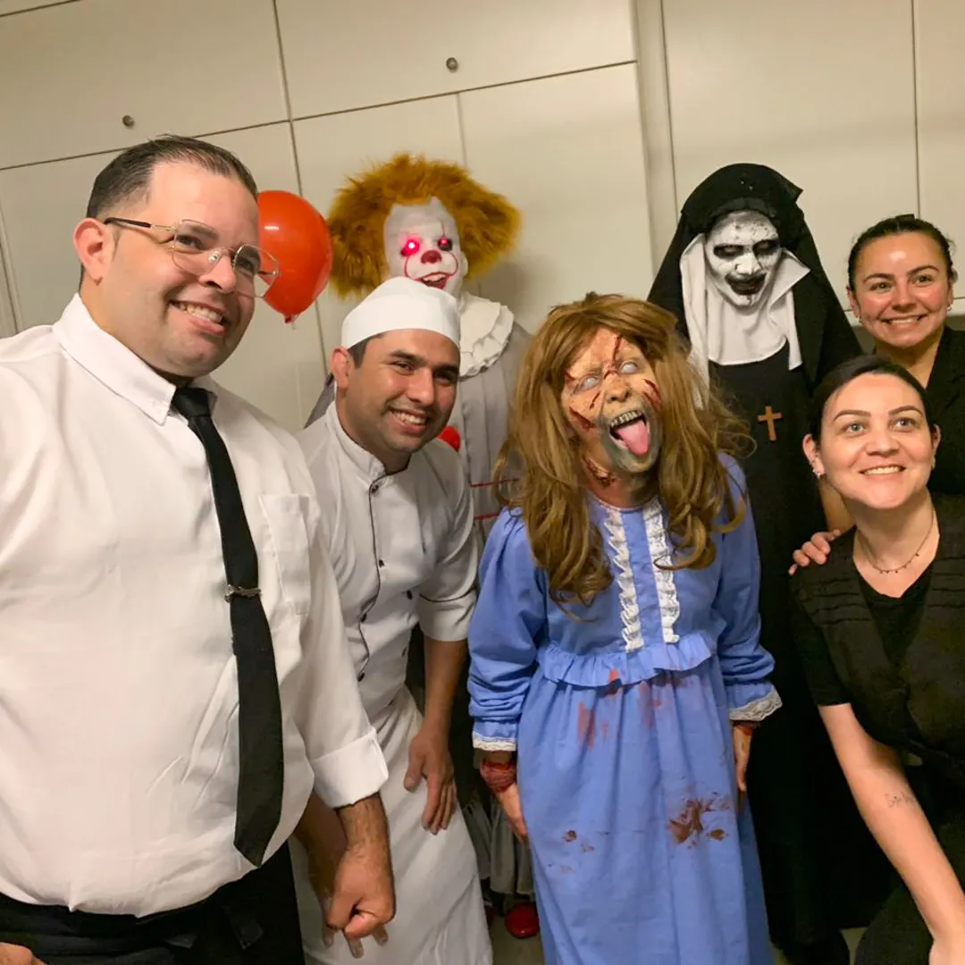 jovens tirando foto divertida com personagem de terror em espaço instagramável de evento.