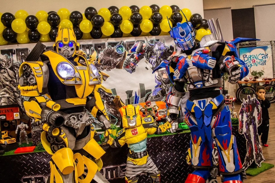 Optimus Prime e Bumblebee interagindo com criancas em festa infantil