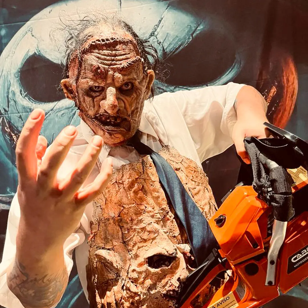 Personagem assustador de filme de horror fazendo performance e interagindo com convidados em festa.